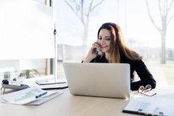 Woman talking on the phone and using laptop computer
